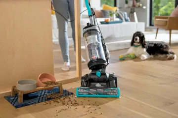 CleanView Swivel Pet Reach Vacuum vacuuming dog food around cabnet.