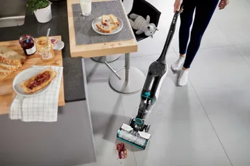 CrossWave Cordless Max Multi-Surface Wet Dry Vac vacuuming and mopping up spilled mess on tile floors.
