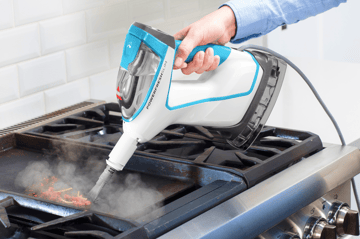 Using Hand Steamer with tool to steam kitchen stove.