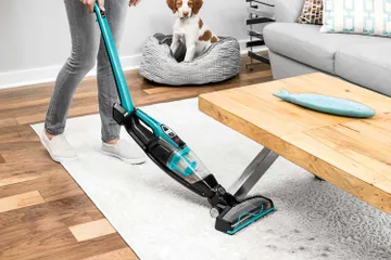 Using ReadyClean Cordless Sick Vac bending handle to vacuum under table.