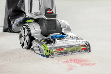 Using CleanShot Pretreater on foot to spray stain on carpet.