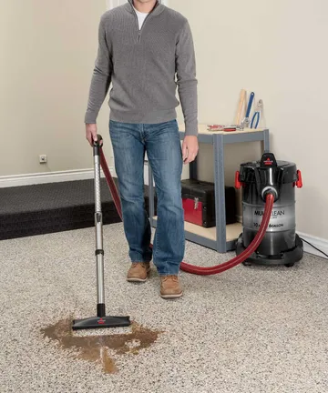 Using Wand with foot to vacuum spill from garage flooring.