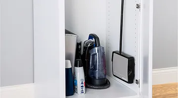 Sturdy Sweep™ Manual Sweeper stored in compact cabinet.