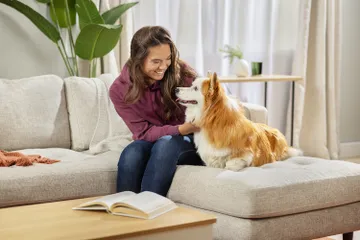 Woman and dog sitting on couch