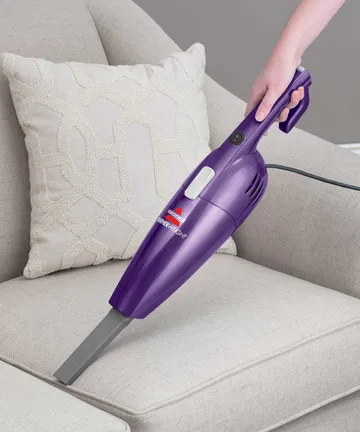 Using Hand Vac with Crevice Tool to vacuum couch cushion.