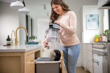 Emptying dirt from dirt bin into trash.
