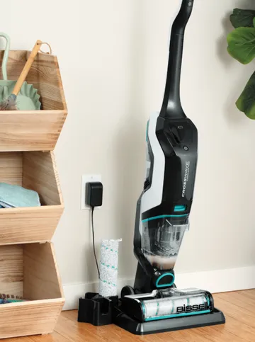 CrossWave Cordless Max charging with CrossWave brush next to it on hard flooring.