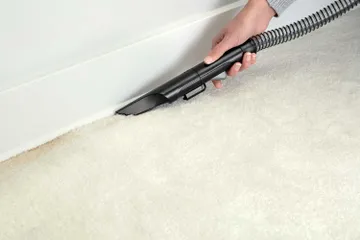 Using Spraying Crevice Tool to clean along baseboards.