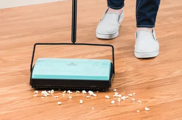 REFRESH Manual Sweeper sweeping popcorn from hard flooring.