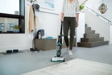 CrossWave Cordless Max using Mutli Surface Brush roll to clean area rug and tiled flooring.