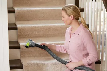 Using Pet TurboBrush on hose to vacuum stairs.