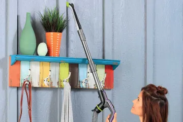 Using Extension wand on hose with tool to vacuum areas above flooring.