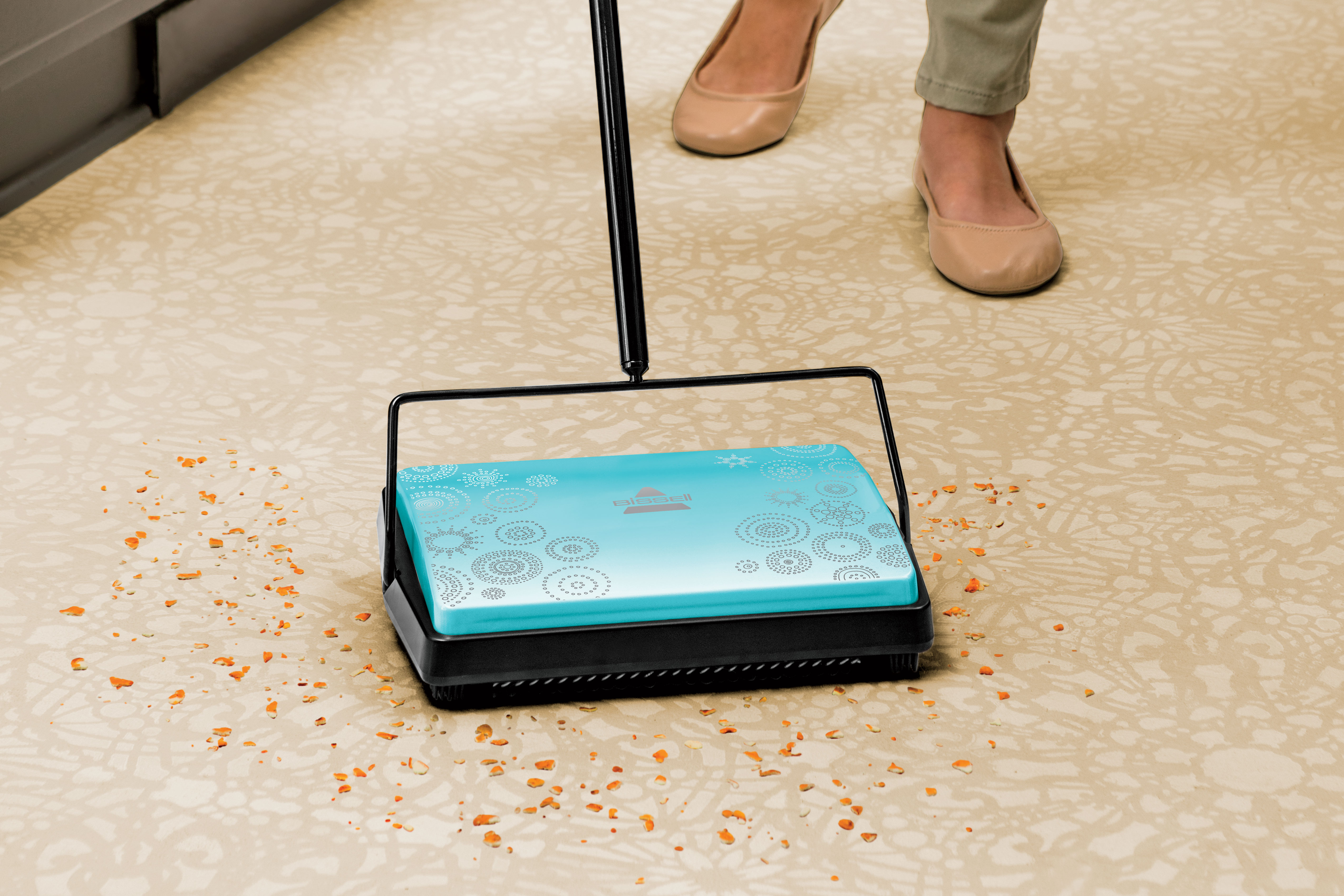 REFRESH Manual Sweeper picking up crumbs off rug.