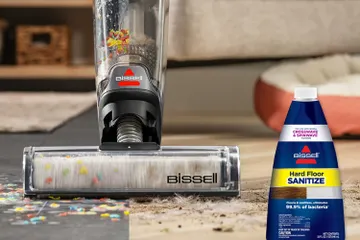 CrossWave OmniForce mopping and vacuuming spill on hard floors and area rug with bottle of Hard Floor Sanitize Formula