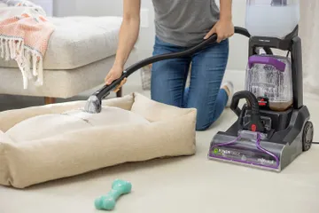 Using hose and tough stain tool to clean pet bed