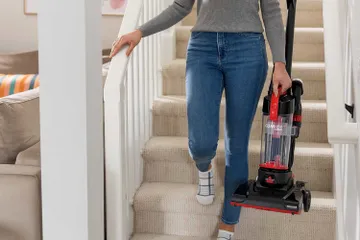 Carrying CleanView Compact Vacuum down the stairs.