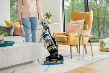 CleanView Swivel Rewind Vacuum vacuuming around furniture.