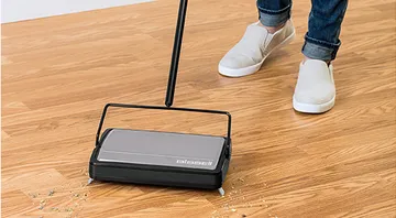Sturdy Sweep™ Manual Sweeper picking up dirt and crumbs on hard flooring.