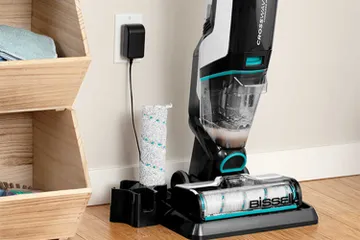 CrossWave Cordless Max Multi-Surface Wet Dry Vac on storage cleaning try with brush roll in holder.