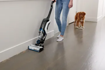 CrossWave Cordless Max Multi-Surface Wet Dry Vac vacuuming pet hair along baseboard.