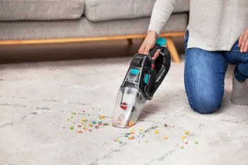 Pet Stain Eraser Dry Hand Vacuum attachment cleaning mess off area rug.