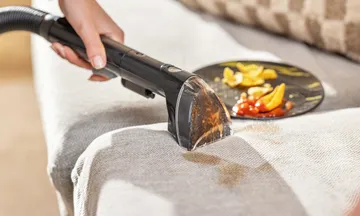 Using Tough Stain Tool to clean spill on couch cushion.