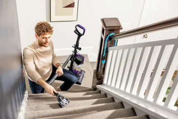 Using Pet TurboBrush Tool on end of hose to vacuum stairs.
