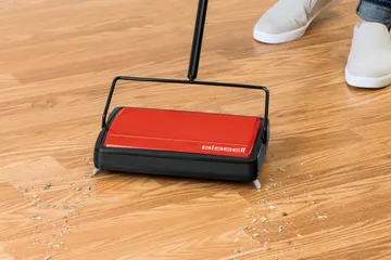 REFRESH Manual Sweeper picking up dirt and crumbs on hard flooring.