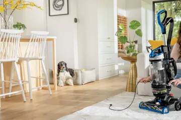 Rewinding cord back into machine of CleanView Swivel Rewind Vacuum.