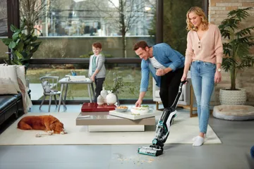 Using CrossWave Cordless Max Wet Dry Vac in living area with hard floors and area rug.