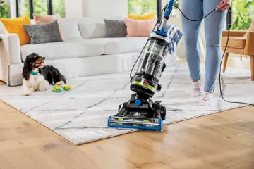 CleanView Swivel Rewind Vacuum moving from area rug to hard flooring.