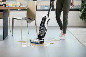 CrossWave Cordless Max Multi-Surface Wet Dry Vac vacuuming and mopping up spilled mess on tile floors.