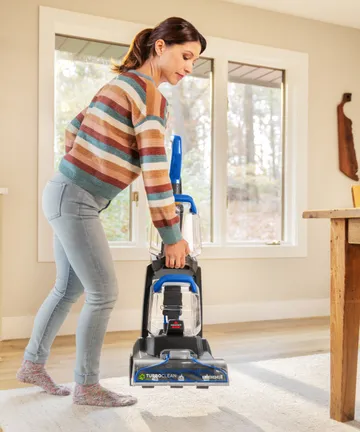 Lifting TurboClean Pet XL Carpet Cleaner to move.