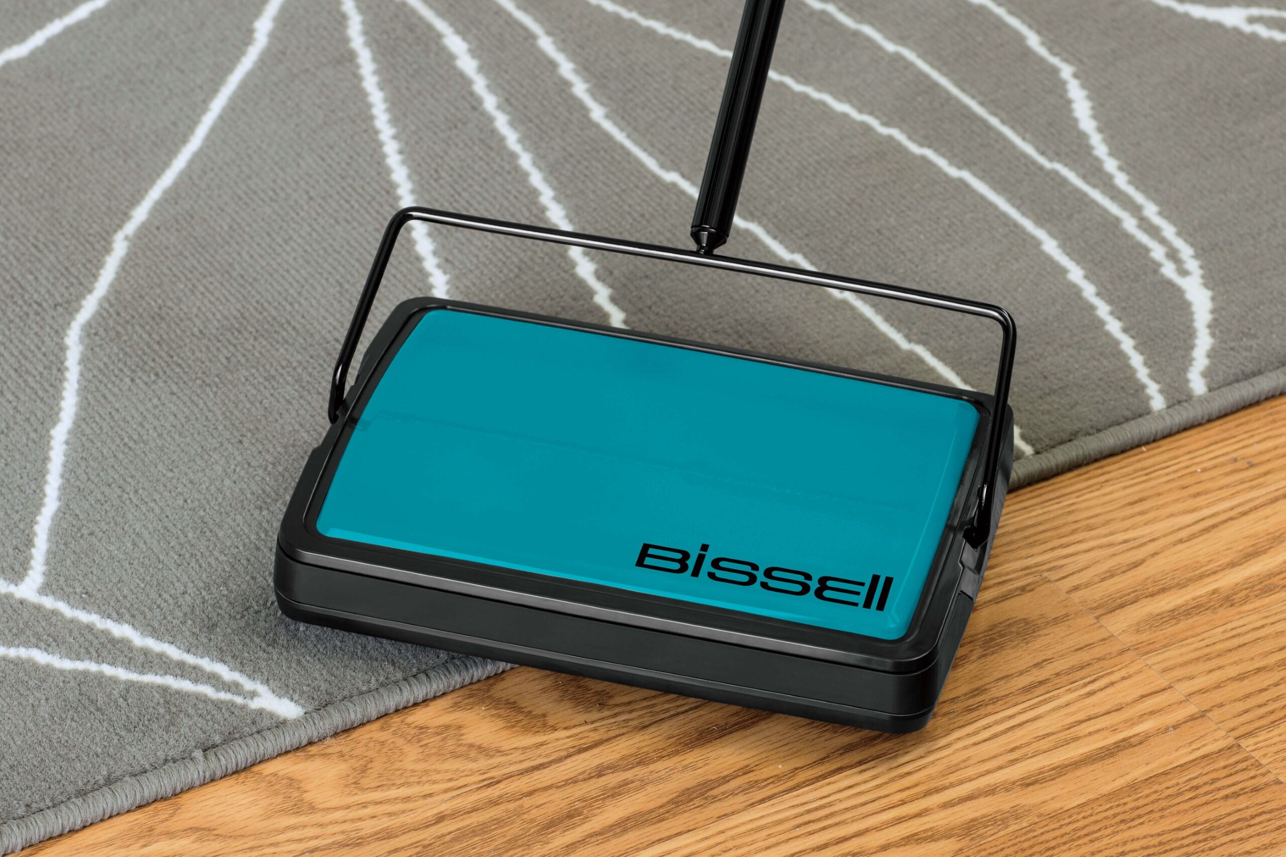 EasySweep Manual Sweeper cleaning hardwood floor and area rug.