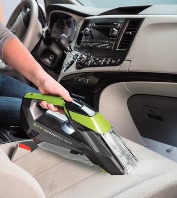 Using Pet Stain Eraser Portable Cleaner to clean stain on couch cushion.