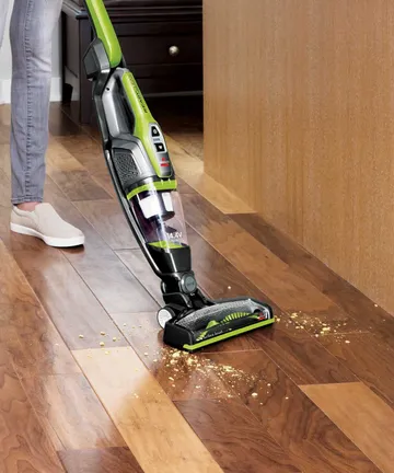 Using ReadyClean Cordless XRT Stick Vac to vacuum crumbs off hard flooring.
