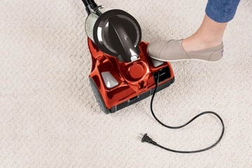 Rewinding cord back into Zing Bagless Canister Vacuum.