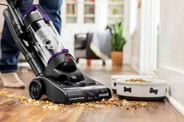 CleanView Compact Turbo Vacuum vacuuming dog food from hard flooring.