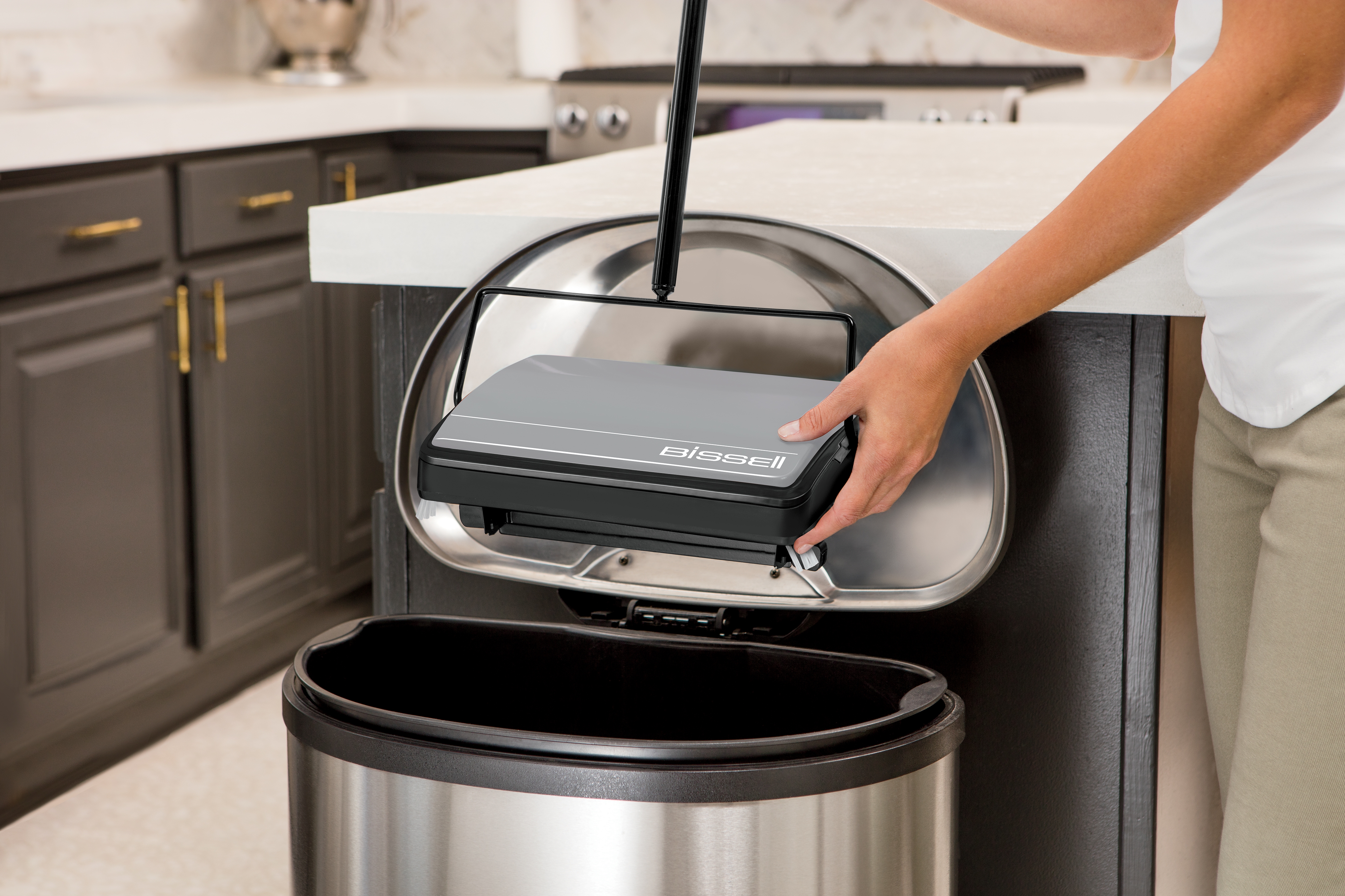 Balayeuse manuelle Sturdy Sweep™ en cours de vidange dans les ordures.