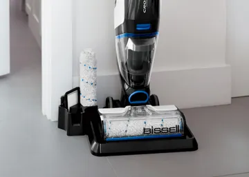 CrossWave Cordless Max Multi-Surface Wet Dry Vac on storage cleaning try with brush roll in holder.